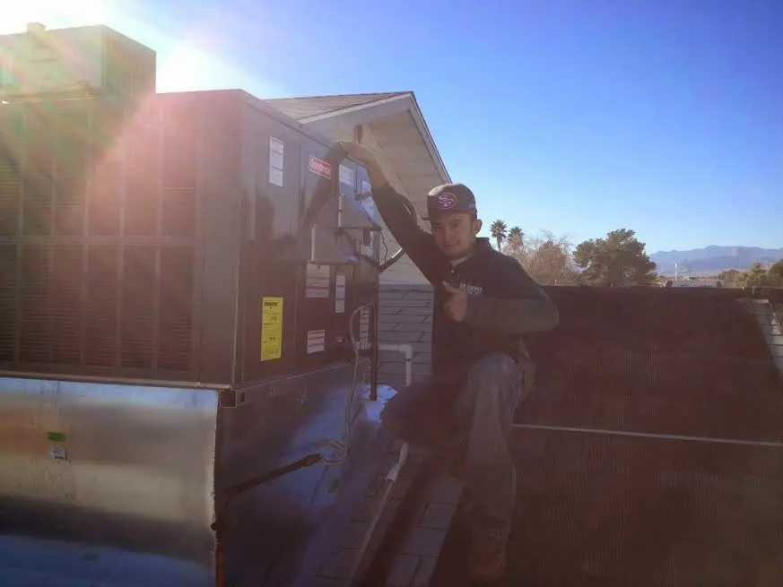 HVAC technician performing HVAC Inspection on a rooftop unit in Ulysses